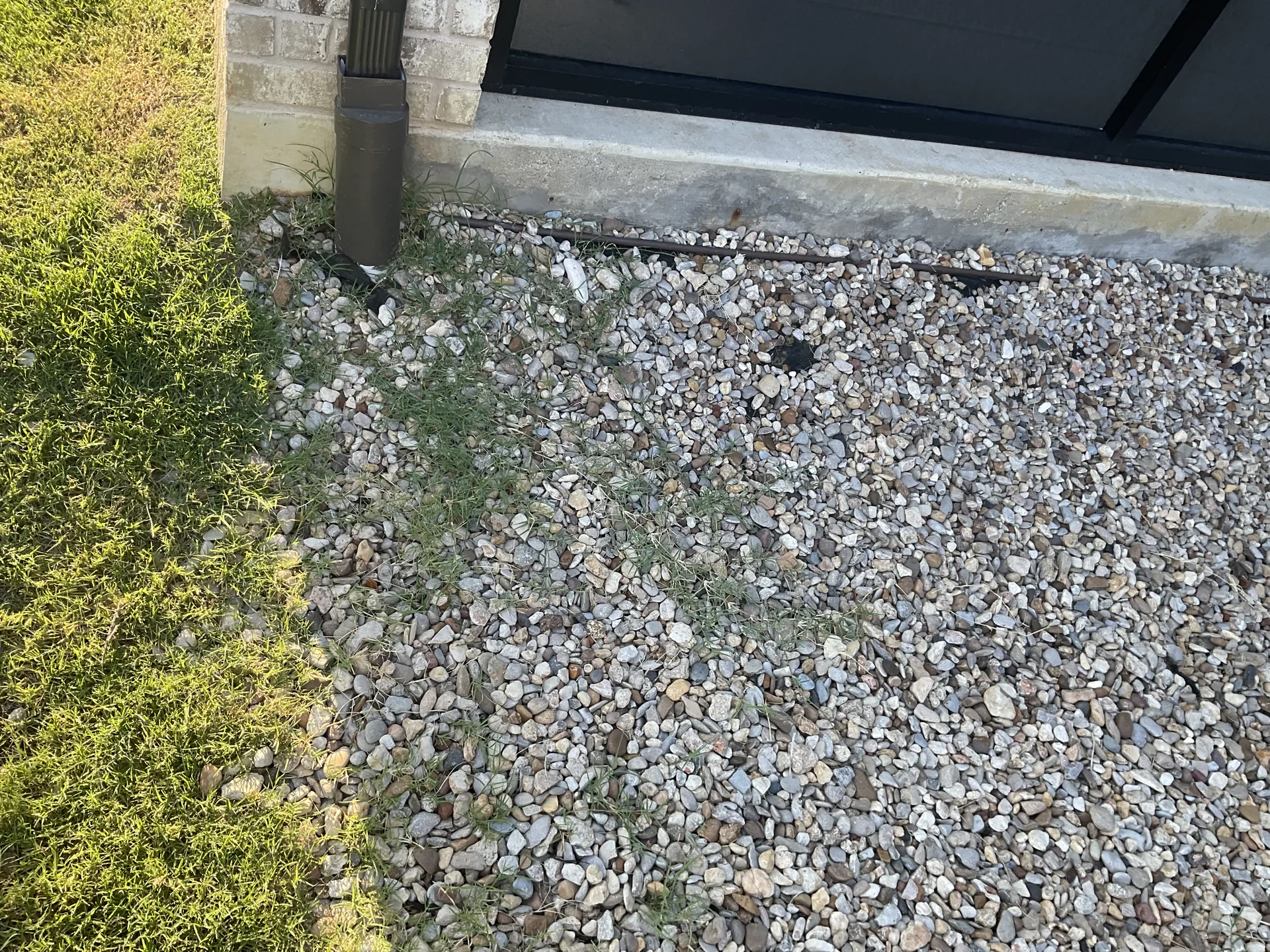 Finished rock lined french drain discharge bed guiding surface stormwater to municipal drainage easement