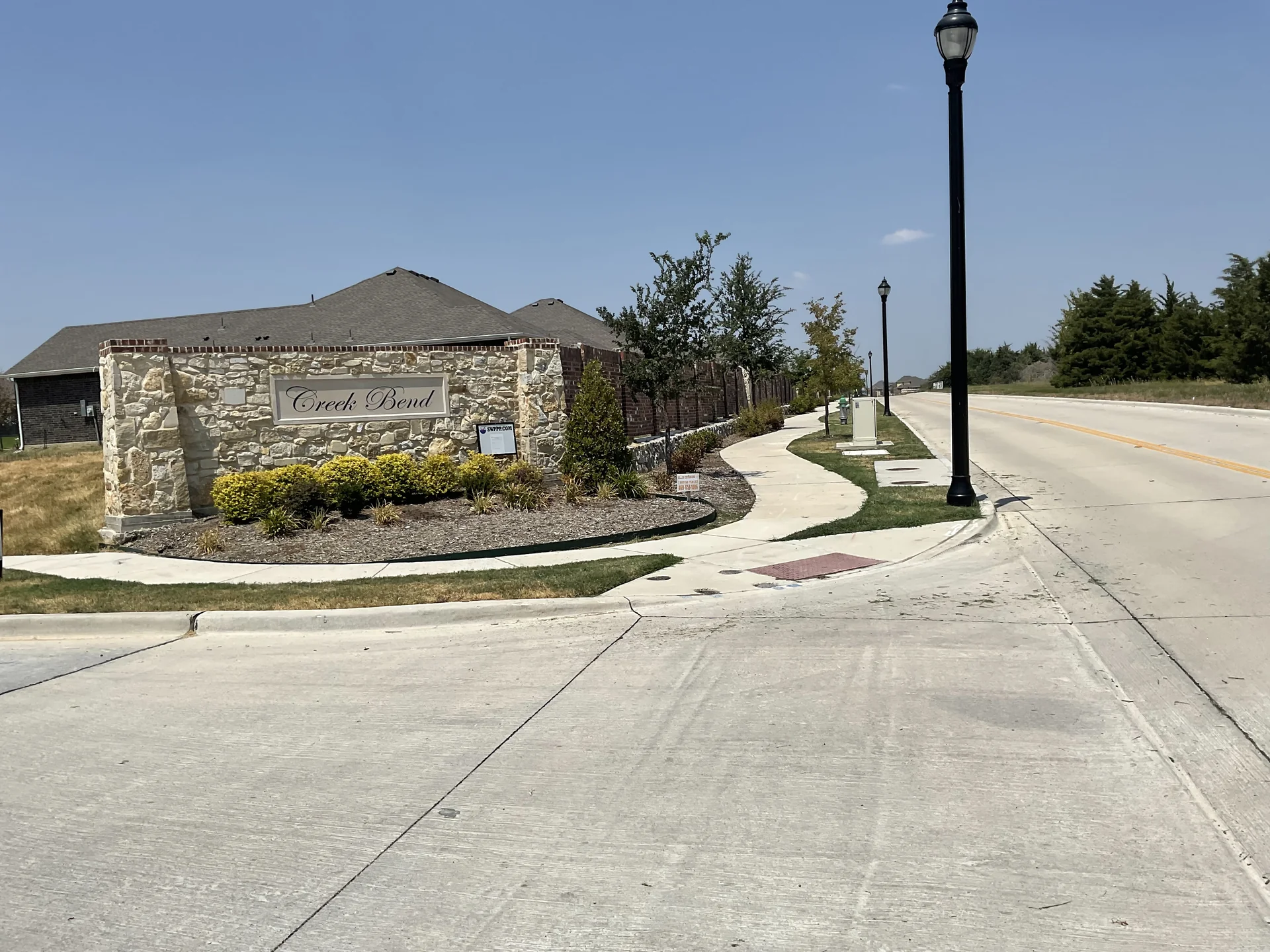 Tree placement distanced from stone retaining walls and paved walkways